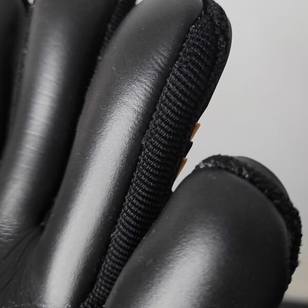 image of finger gussets, which are the small panels of fabric or material sewn between the fingers of goalkeeper gloves. They serve to improve breathability, allowing air to flow through and keep the hands cooler during play. Gussets also enhance flexibility and range of motion, ensuring that the gloves move naturally with the hand for a more comfortable fit and better grip control, especially during key saves or throws.